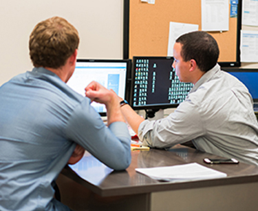 Two Meyer colleagues reviewing figures on a monitor together